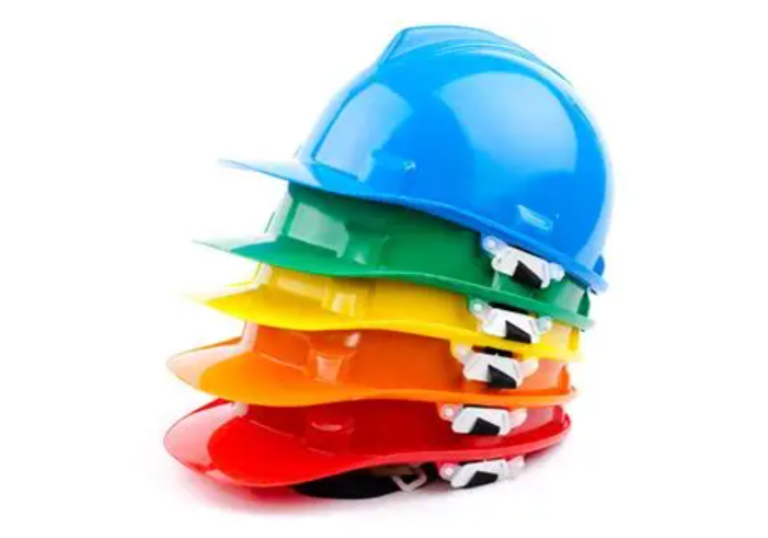 Picture of differently colored hard hats stacked on top of each other